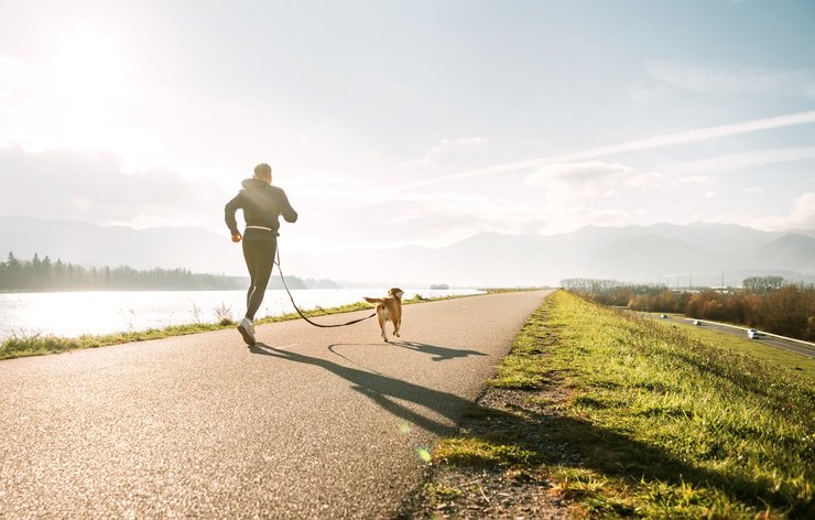 woman jogging with dog on leash morning